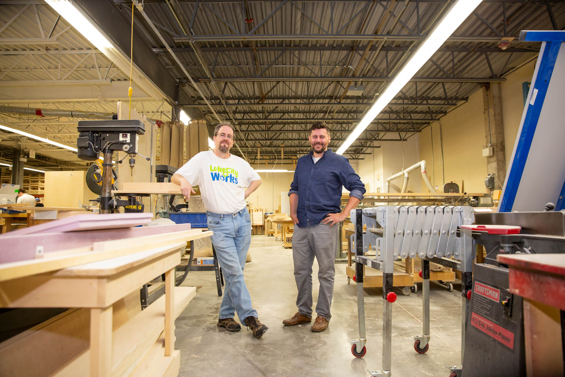 Photo of George Parsons and owner of Lake City Woodworkers standing together in the wood shop