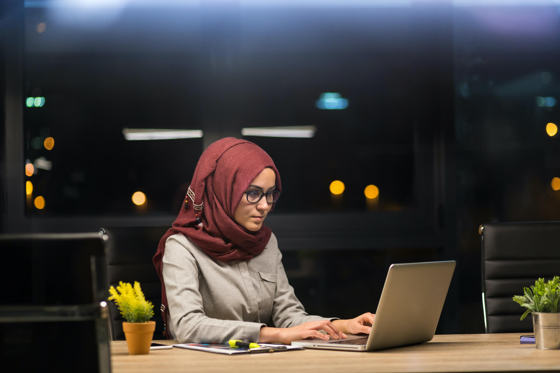 woman wearing a hijab working at an office